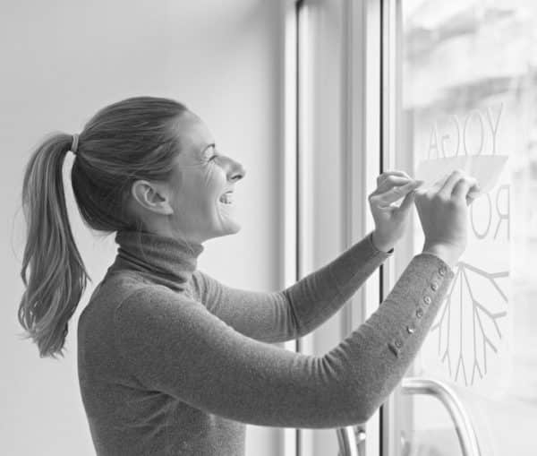 Woman applying decal to window