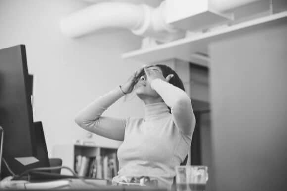 Worker dealing with employee burnout at her office desk