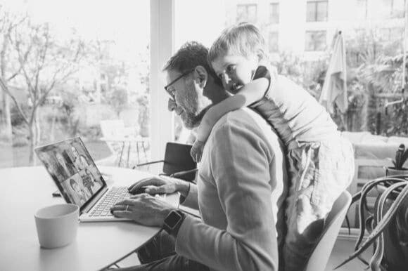 Employee working from home with kid on his back